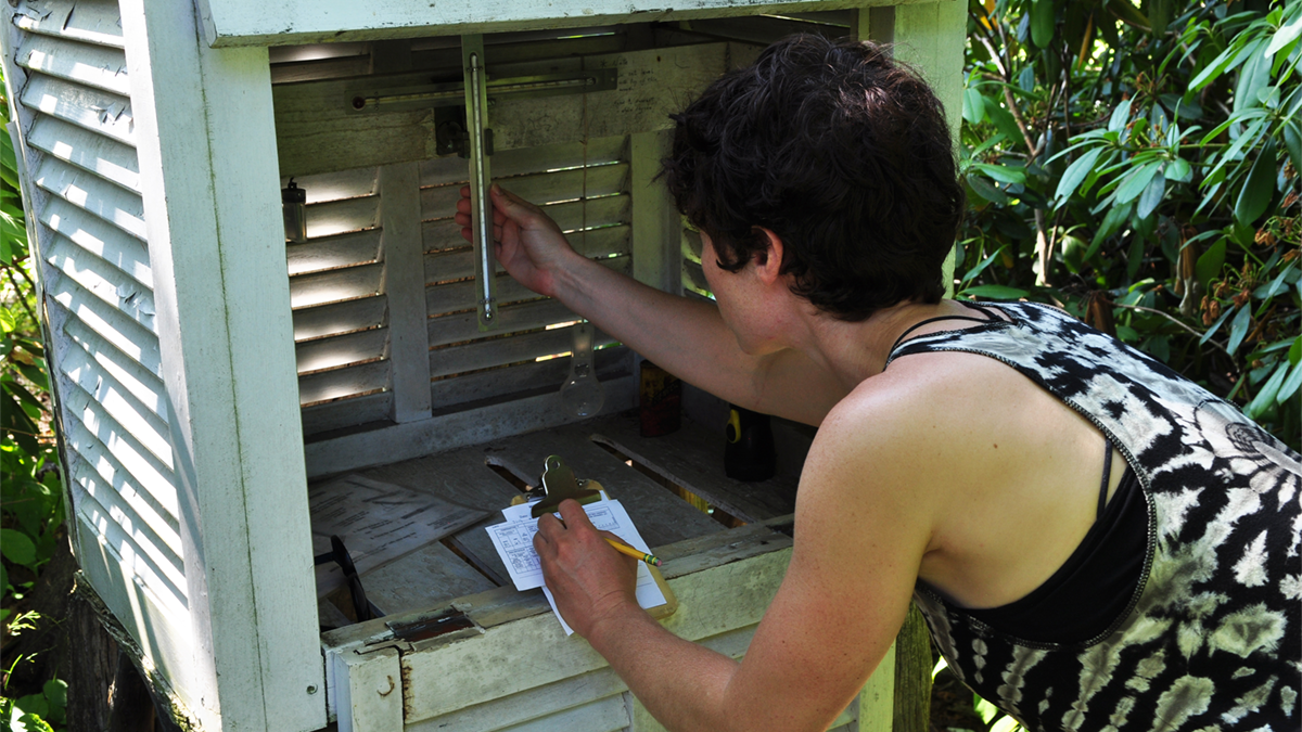 A volunteer checks the rain gauge at Lake Mohonk as part of Mohonk Preserve's daily tracking of climate data, one of the most continuous and consistent climate records in North America.