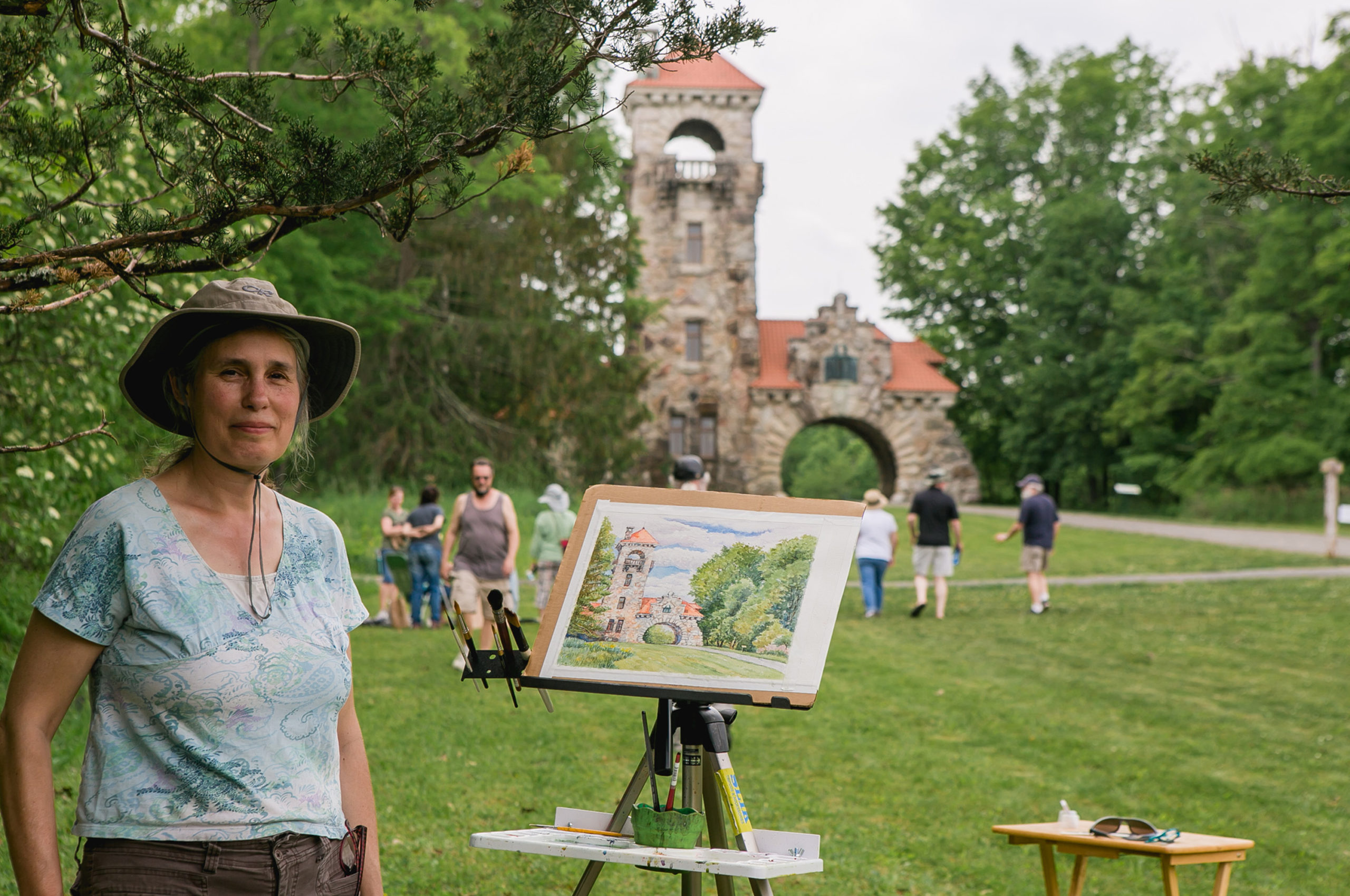 Artist posing with their painting at the Plein Air Artwalk