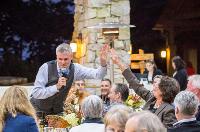 Auctioneer Alex Sherwood gives a high five to an audience member at the Preserve's Auction