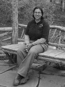 Intern sits on rustic cedar bench