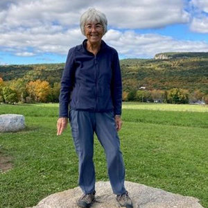 Tonda Highley at Mohonk Preserve foothills on a summer day, skytop tower and the Shawangunk Ridge in the background.