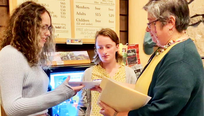 Three individuals discuss future leaders award in the Mohonk Preserve Visitor Center