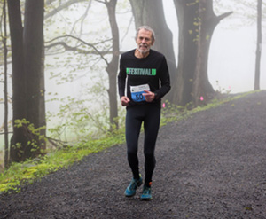 Man running on path in foggy woods