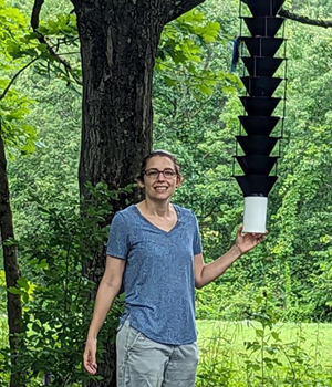 Abby stands next to a southern pine beetle pheromone trap
